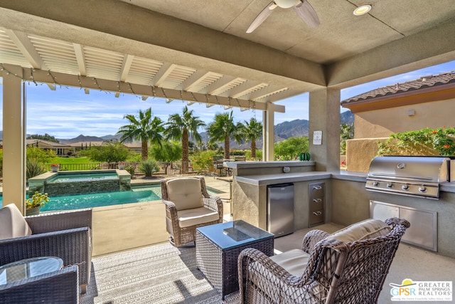 view of patio / terrace with a mountain view, exterior kitchen, an outdoor hangout area, and grilling area