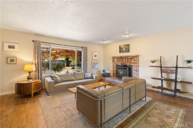 12755 Blue Heron Ct, Clearlake Oaks, CA 95423 - living room with a wood stove, a textured ceiling, and hardwood / wood-style flooring