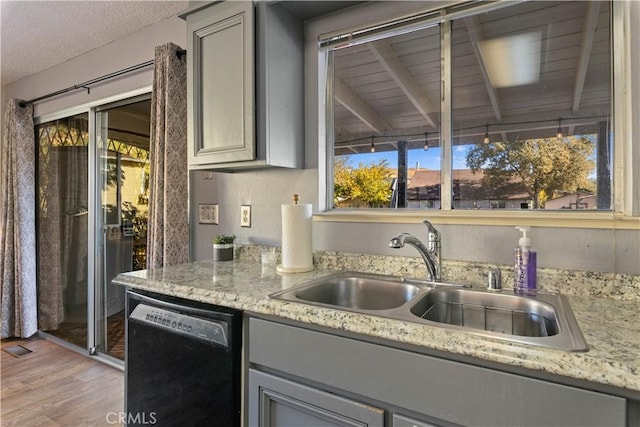 12755 Blue Heron Ct, Clearlake Oaks, CA 95423 - kitchen featuring light stone countertops, sink, gray cabinets, dishwasher, and light hardwood / wood-style floors