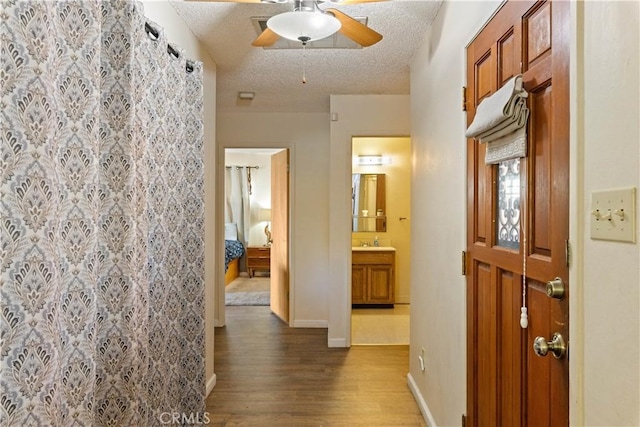 12755 Blue Heron Ct, Clearlake Oaks, CA 95423 - corridor with sink, a textured ceiling, and hardwood / wood-style flooring