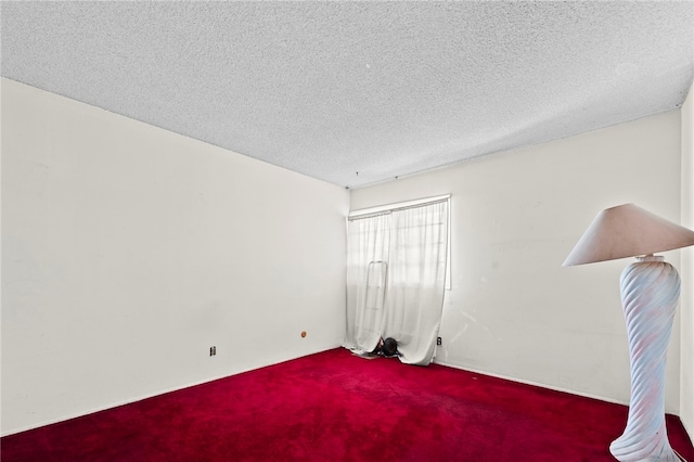 carpeted spare room featuring a textured ceiling