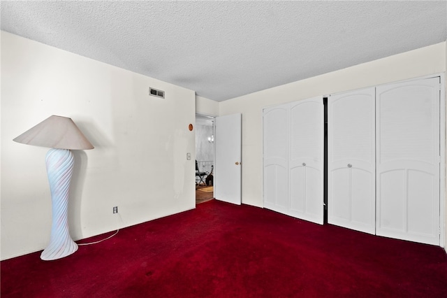 unfurnished bedroom featuring carpet flooring and a textured ceiling