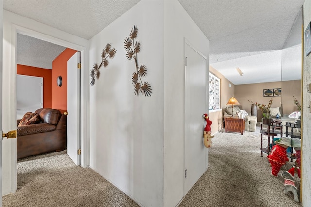 corridor with carpet and a textured ceiling