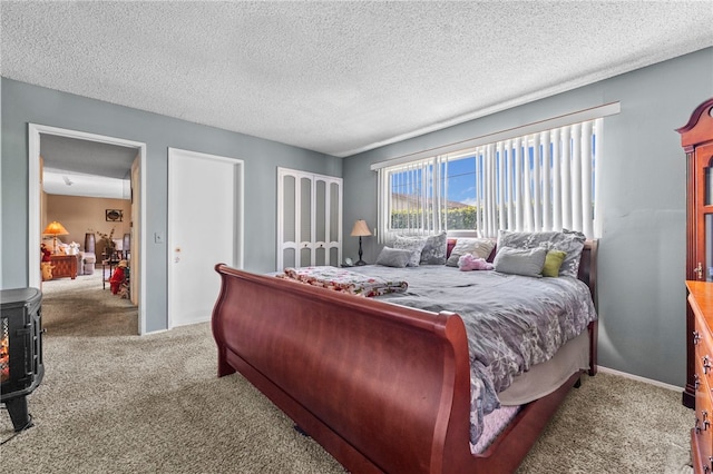 carpeted bedroom featuring a wood stove and a textured ceiling