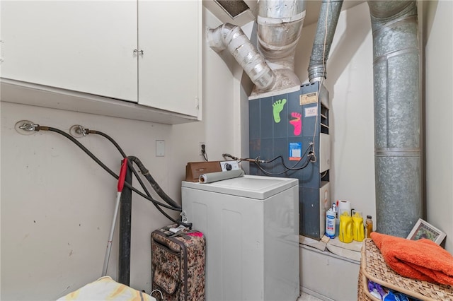 clothes washing area with cabinets and washer / dryer