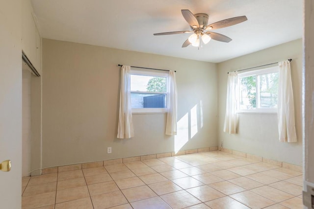 spare room featuring ceiling fan and light tile patterned floors