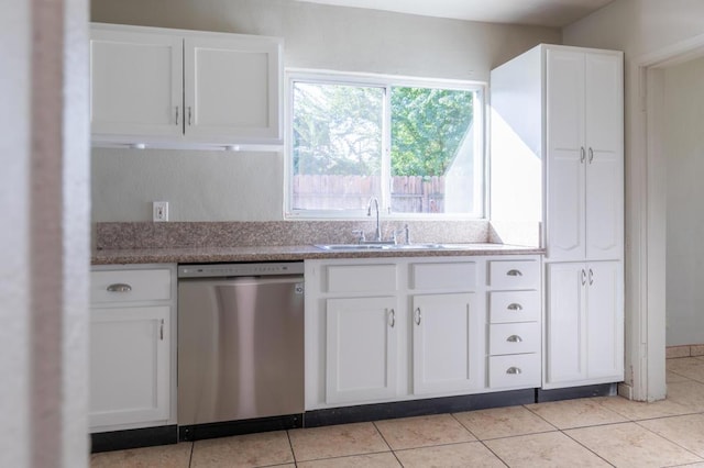 kitchen with white cabinetry, sink, light tile patterned flooring, and stainless steel dishwasher