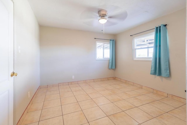 tiled empty room featuring ceiling fan