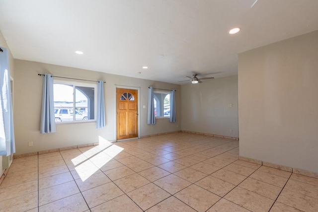 tiled empty room featuring ceiling fan