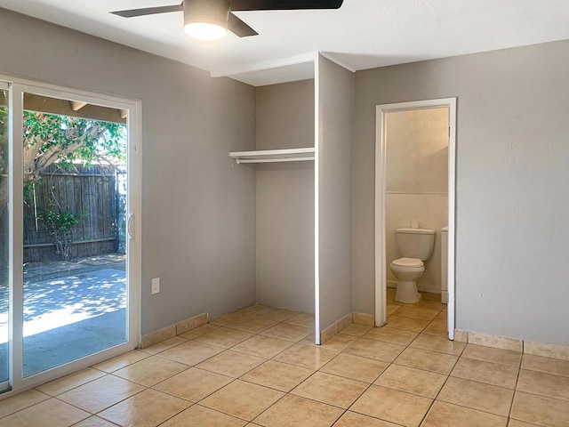 unfurnished bedroom featuring light tile patterned floors, access to outside, ceiling fan, and ensuite bathroom