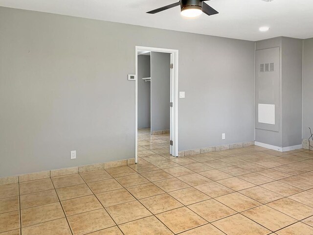 tiled empty room featuring ceiling fan