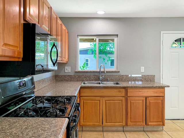 kitchen featuring light tile patterned floors, sink, and black appliances