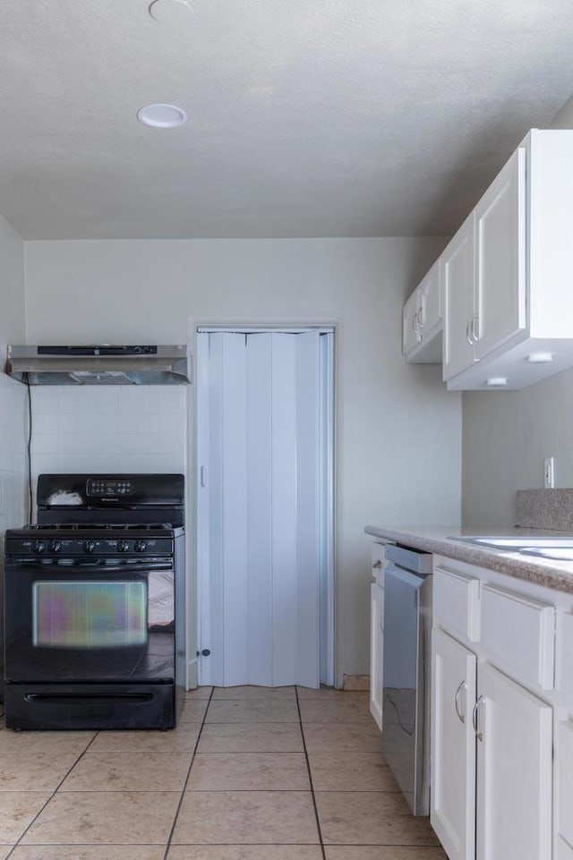 kitchen featuring stainless steel dishwasher, range hood, light tile patterned flooring, white cabinetry, and black range with gas cooktop