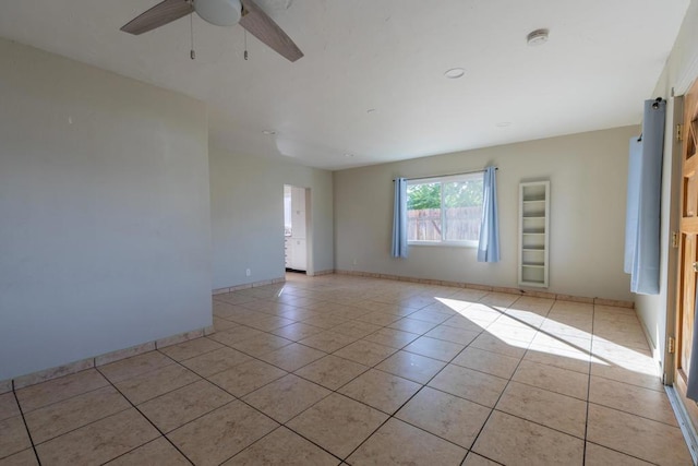 tiled spare room with ceiling fan