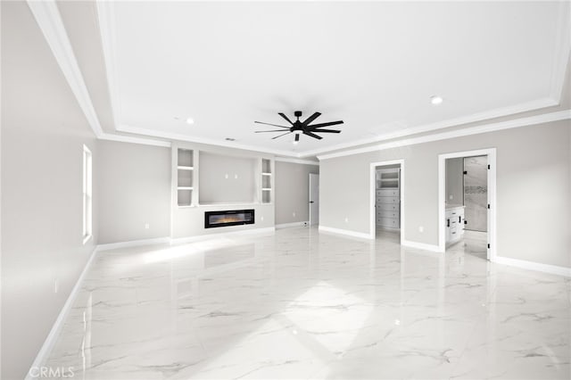 unfurnished living room with ceiling fan, built in features, ornamental molding, and a tray ceiling