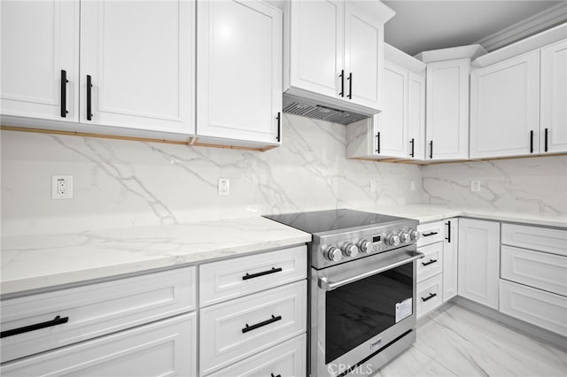 kitchen featuring white cabinets, light stone counters, high end stainless steel range oven, and tasteful backsplash