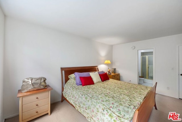 carpeted bedroom featuring ensuite bath