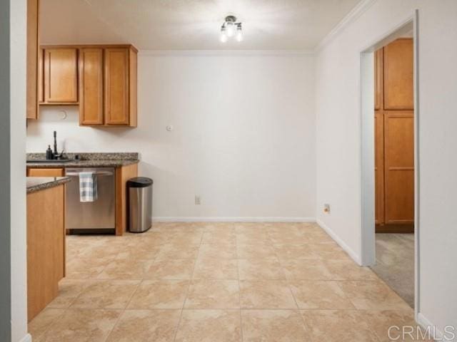 kitchen with stainless steel dishwasher, dark countertops, baseboards, crown molding, and brown cabinetry