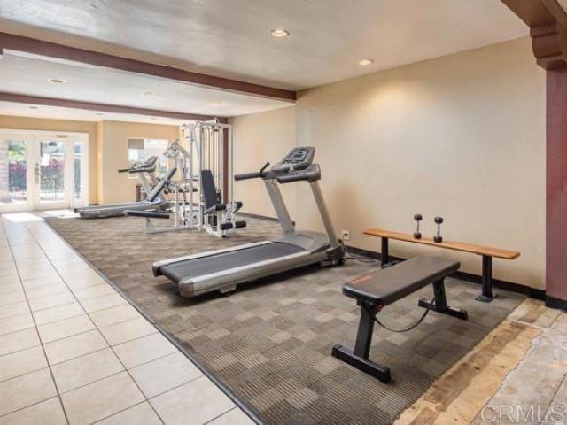 workout area featuring french doors, carpet flooring, baseboards, recessed lighting, and tile patterned flooring