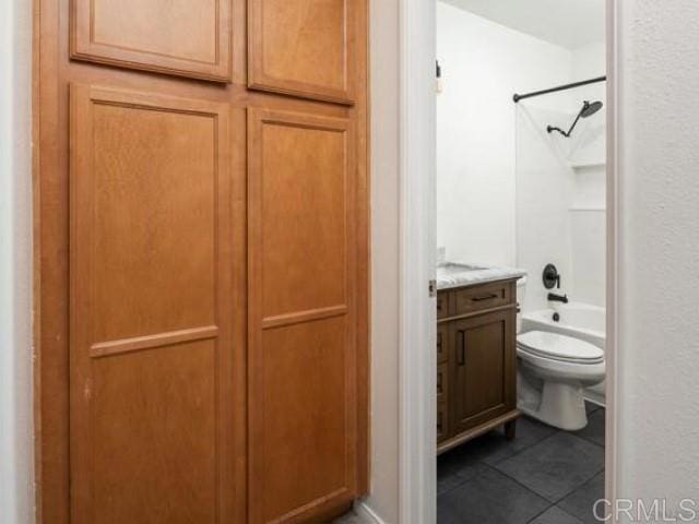 bathroom with tile patterned flooring, vanity, shower / tub combination, and toilet