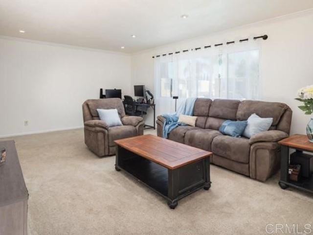 living area featuring light colored carpet and ornamental molding