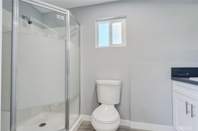 bathroom with hardwood / wood-style floors, vanity, toilet, and walk in shower