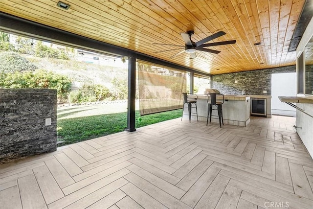 wooden terrace with ceiling fan and exterior bar