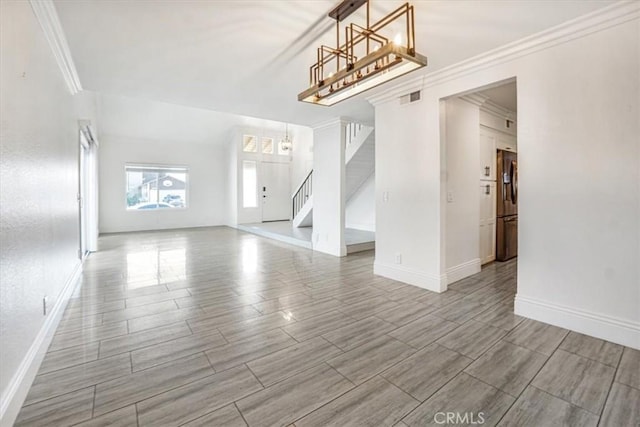 empty room featuring crown molding and a chandelier