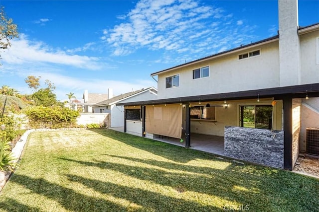 rear view of property featuring a patio and a yard