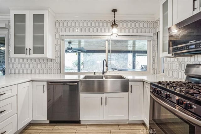 kitchen featuring appliances with stainless steel finishes, backsplash, white cabinetry, and sink