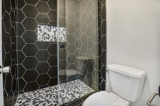 bathroom featuring toilet and tiled shower