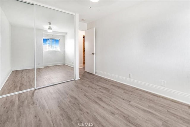 unfurnished bedroom with a closet and wood-type flooring