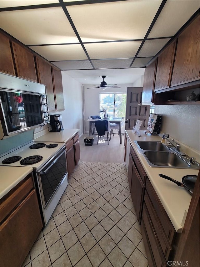 kitchen featuring ceiling fan, sink, dark brown cabinetry, and white range with electric cooktop