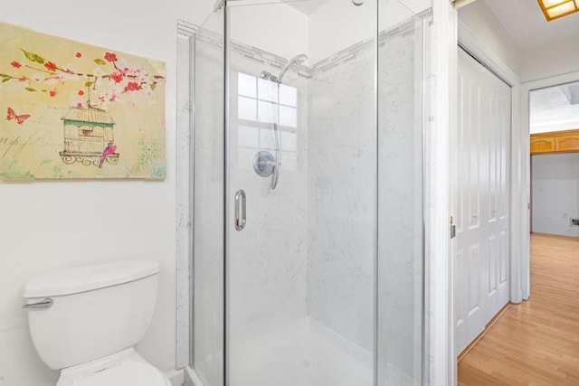 bathroom featuring toilet, hardwood / wood-style floors, and walk in shower