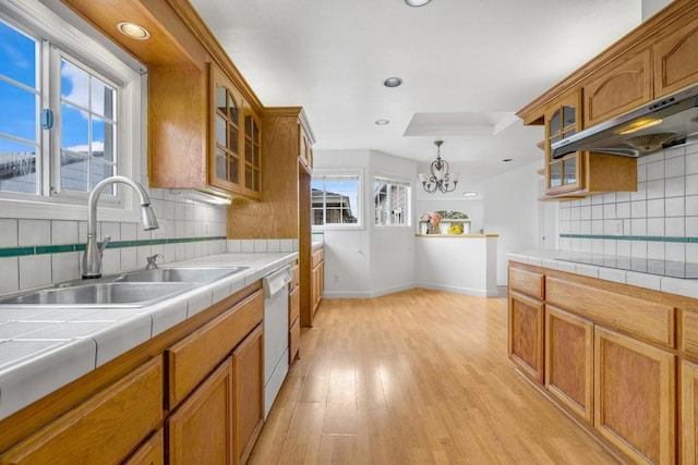 kitchen with extractor fan, pendant lighting, dishwasher, sink, and tile counters