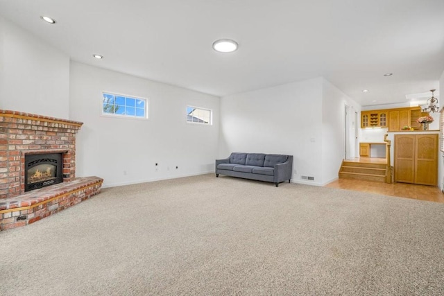 unfurnished room featuring light carpet and a brick fireplace