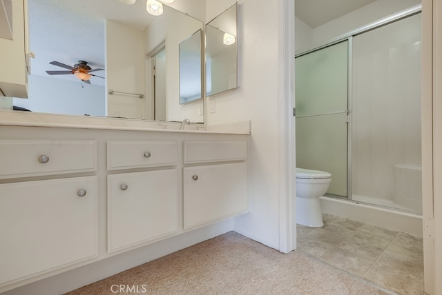 bathroom with ceiling fan, vanity, toilet, and an enclosed shower