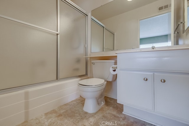 full bathroom featuring vanity, combined bath / shower with glass door, tile patterned floors, and toilet