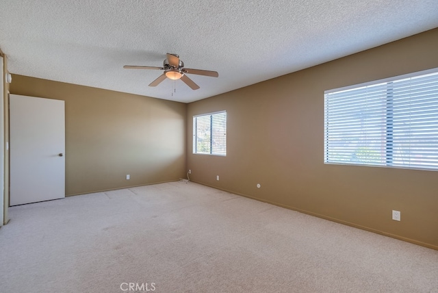 unfurnished room with light carpet, ceiling fan, and a textured ceiling