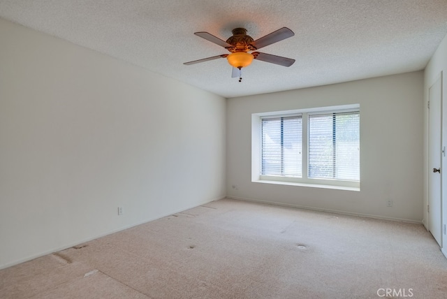 carpeted empty room featuring ceiling fan and a textured ceiling