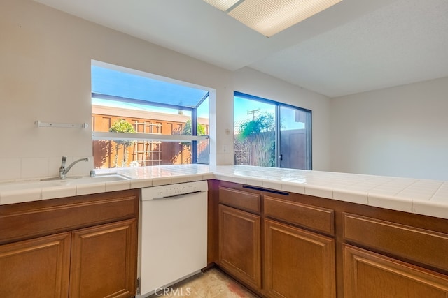 kitchen with tile counters and white dishwasher