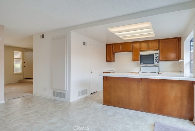 kitchen featuring sink, tile countertops, and kitchen peninsula