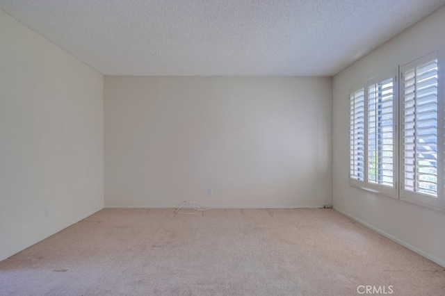 carpeted spare room with a textured ceiling