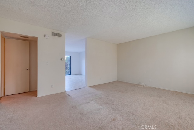 carpeted spare room with a textured ceiling