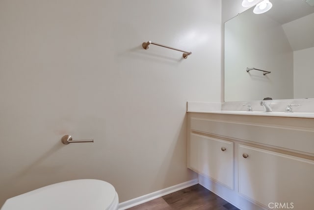 bathroom featuring vanity, hardwood / wood-style floors, and toilet