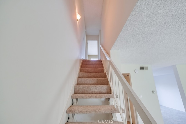 stairway with a textured ceiling