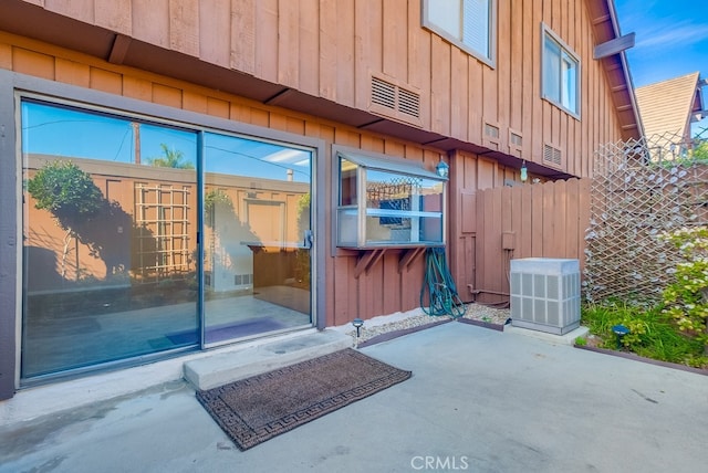 entrance to property featuring cooling unit and a patio