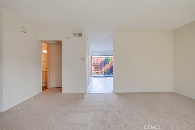 carpeted empty room with a textured ceiling