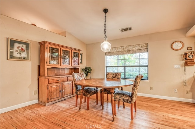 dining space with light hardwood / wood-style flooring and lofted ceiling