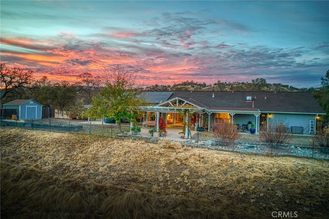 view of front of property with a patio area and a storage shed